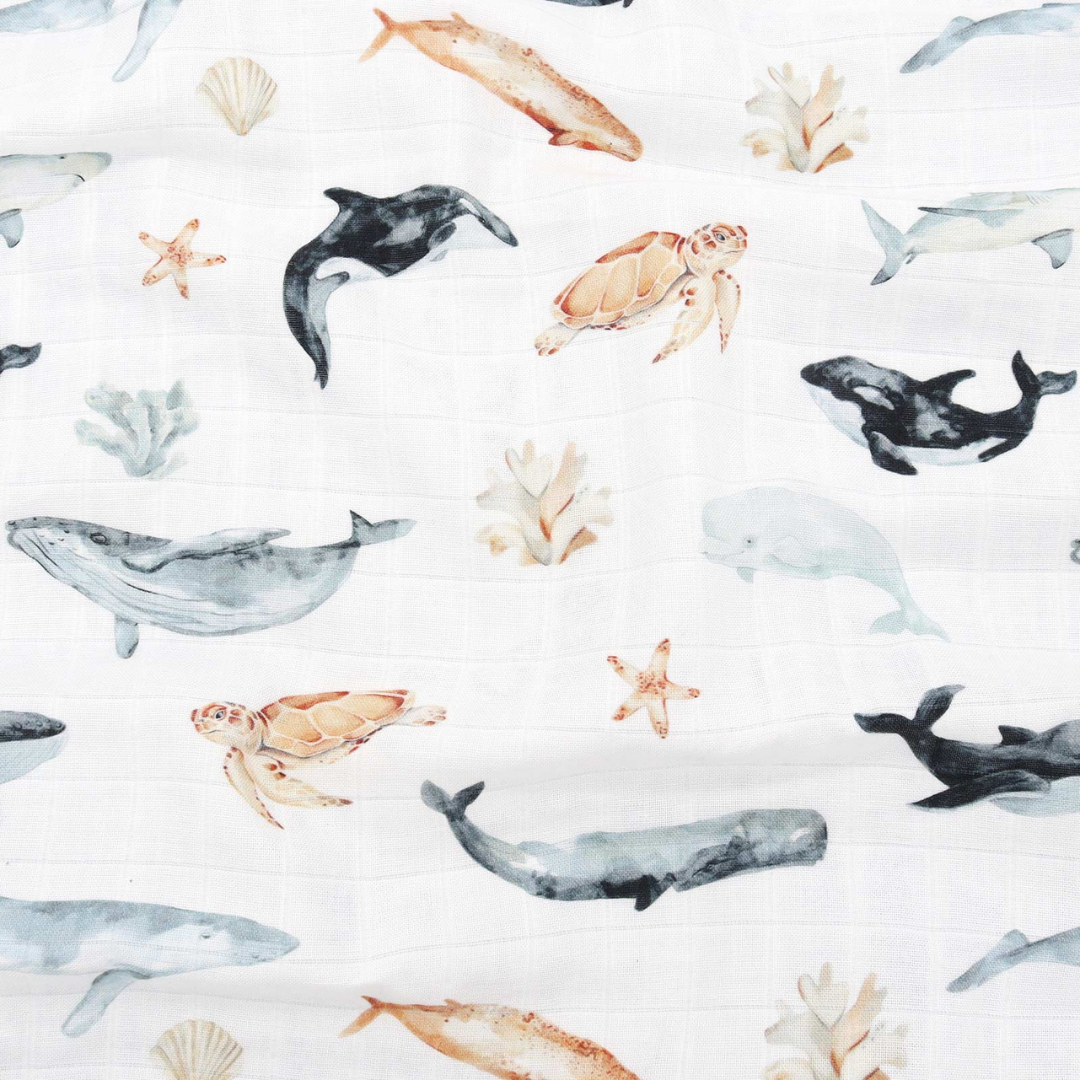 Close-up of ocean animals print with whales, turtles, dolphins, and coral – soft bamboo baby muslin