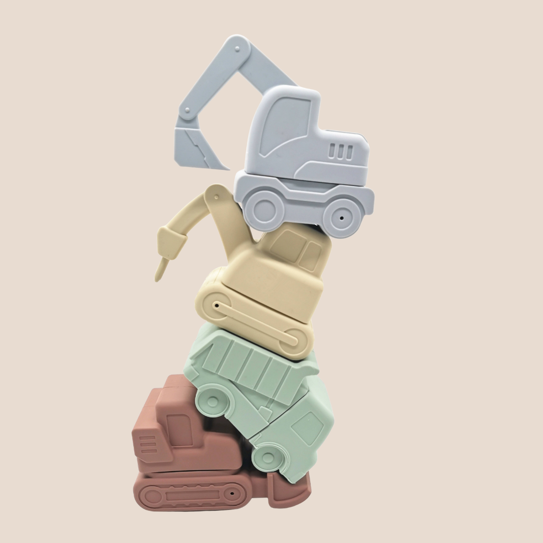 Stack of colorful toy construction vehicles on a beige background