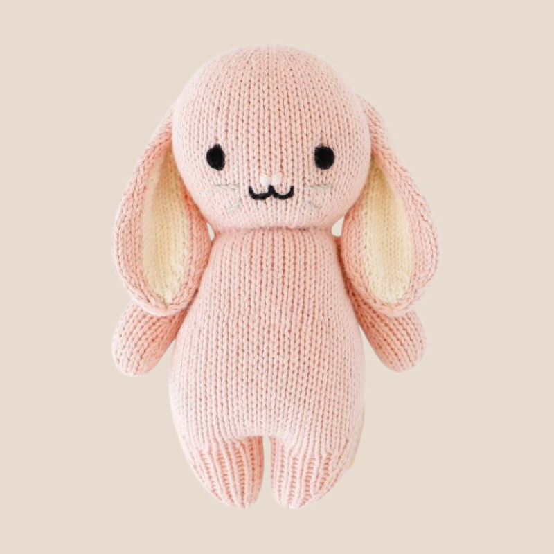 Hand-knitted pink stuffed bunny toy for babies with embroidered face and floppy ears