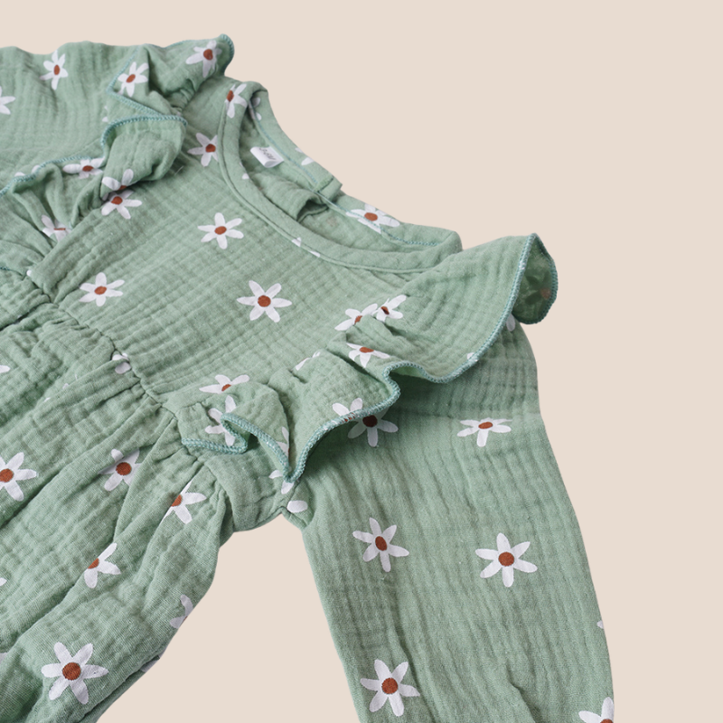 Ruffle shoulder and floral pattern detail of baby girl romper