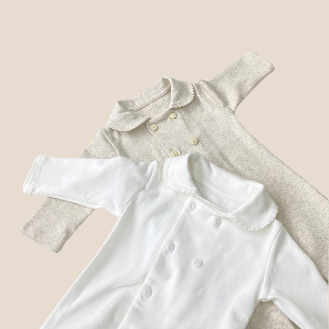 White and gray baby rompers on a beige background