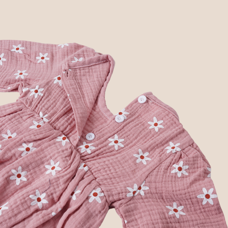 Skirted detail of baby girl cotton romper with white daisy print
