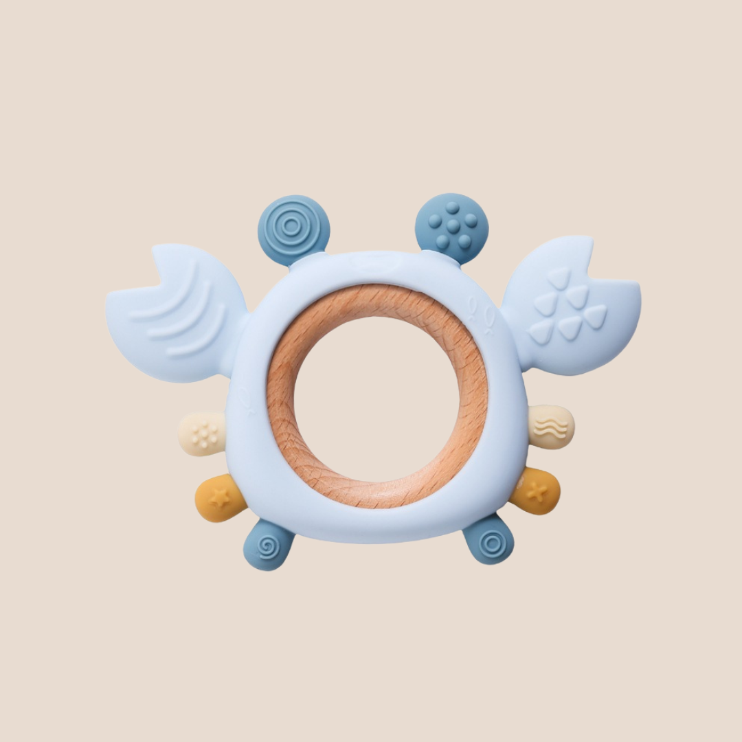 Teething ring with blue and wooden elements on a beige background