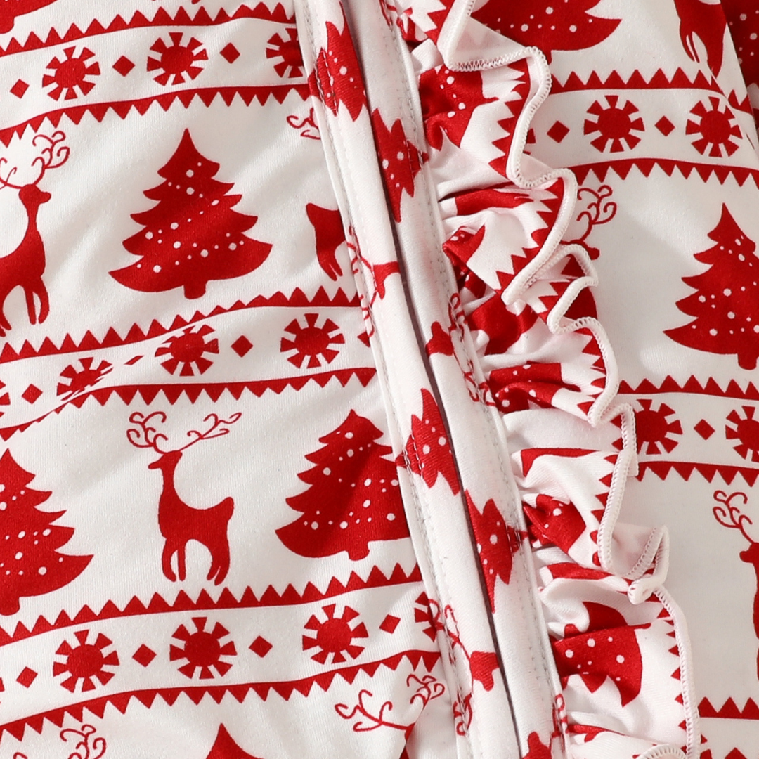 Close-up of red and white festive baby romper fabric showing reindeer and Christmas tree pattern