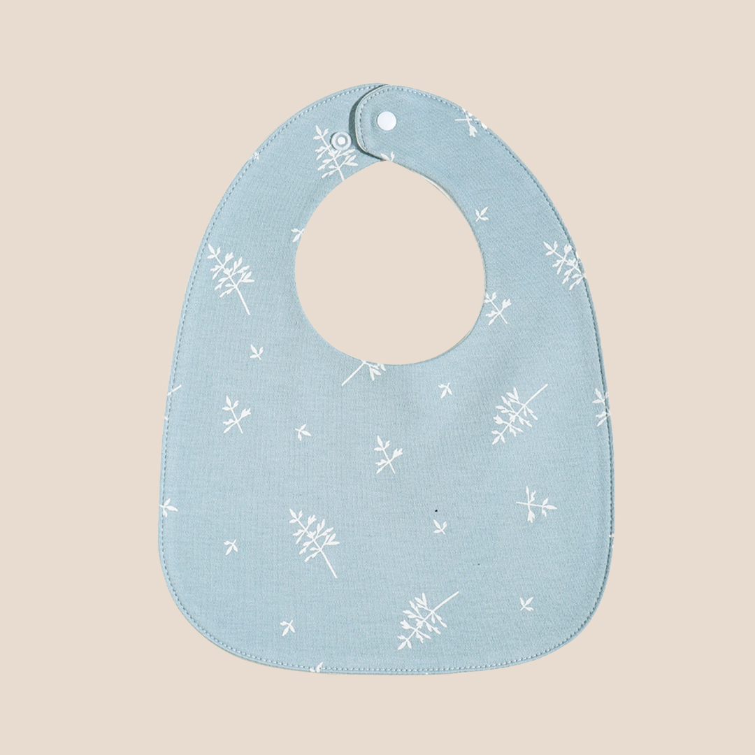 Cotton Craft Organic Cotton Muslin Baby Bib in Blue Dandelion print with adjustable snap closure.