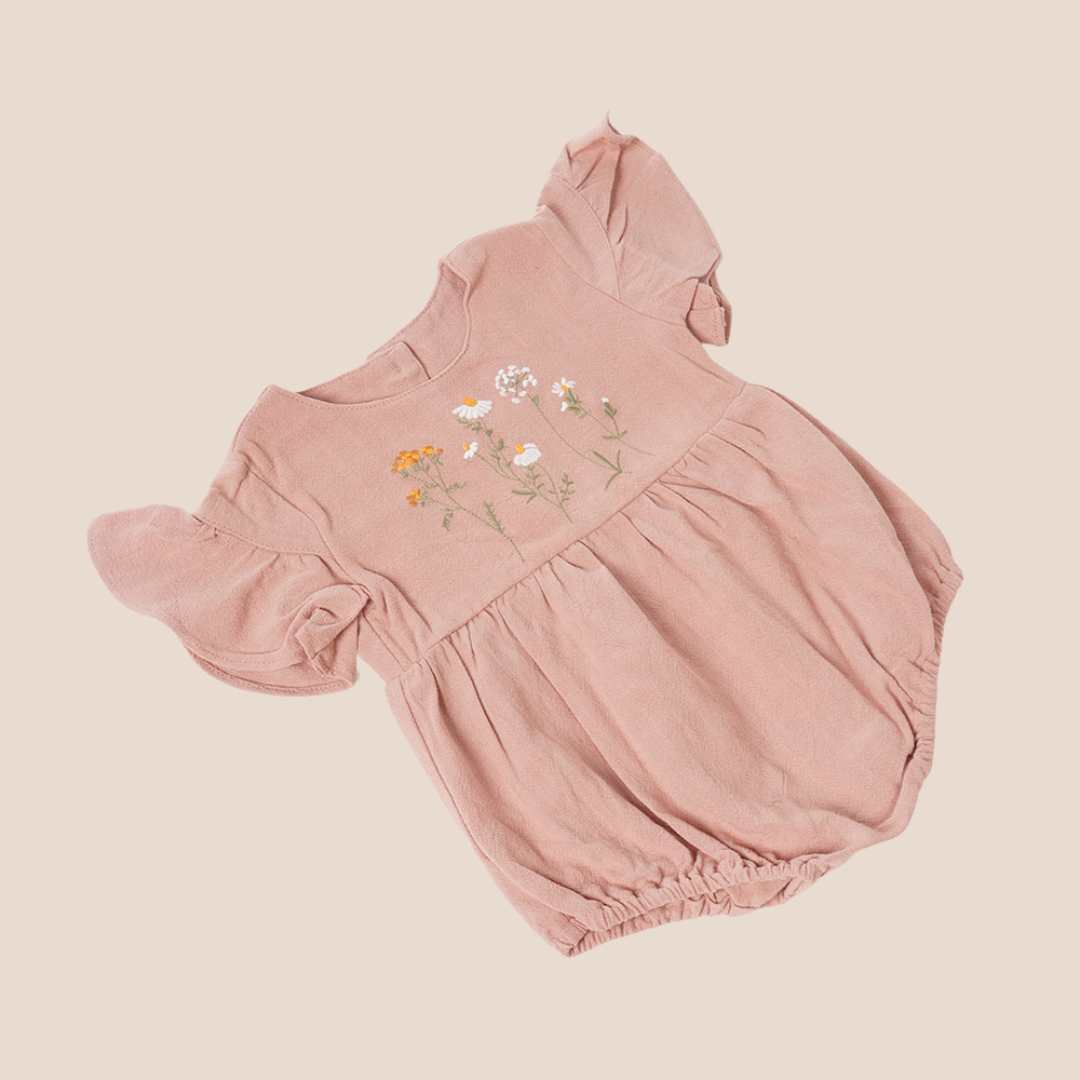 Close-up of wildflower embroidery on baby romper – thoughtful detail for luxury baby gifts and custom newborn gifting