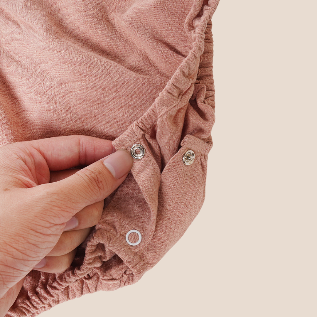 Bottom snap closures on romper for easy changing – beautiful and practical for curated baby shower gift boxes