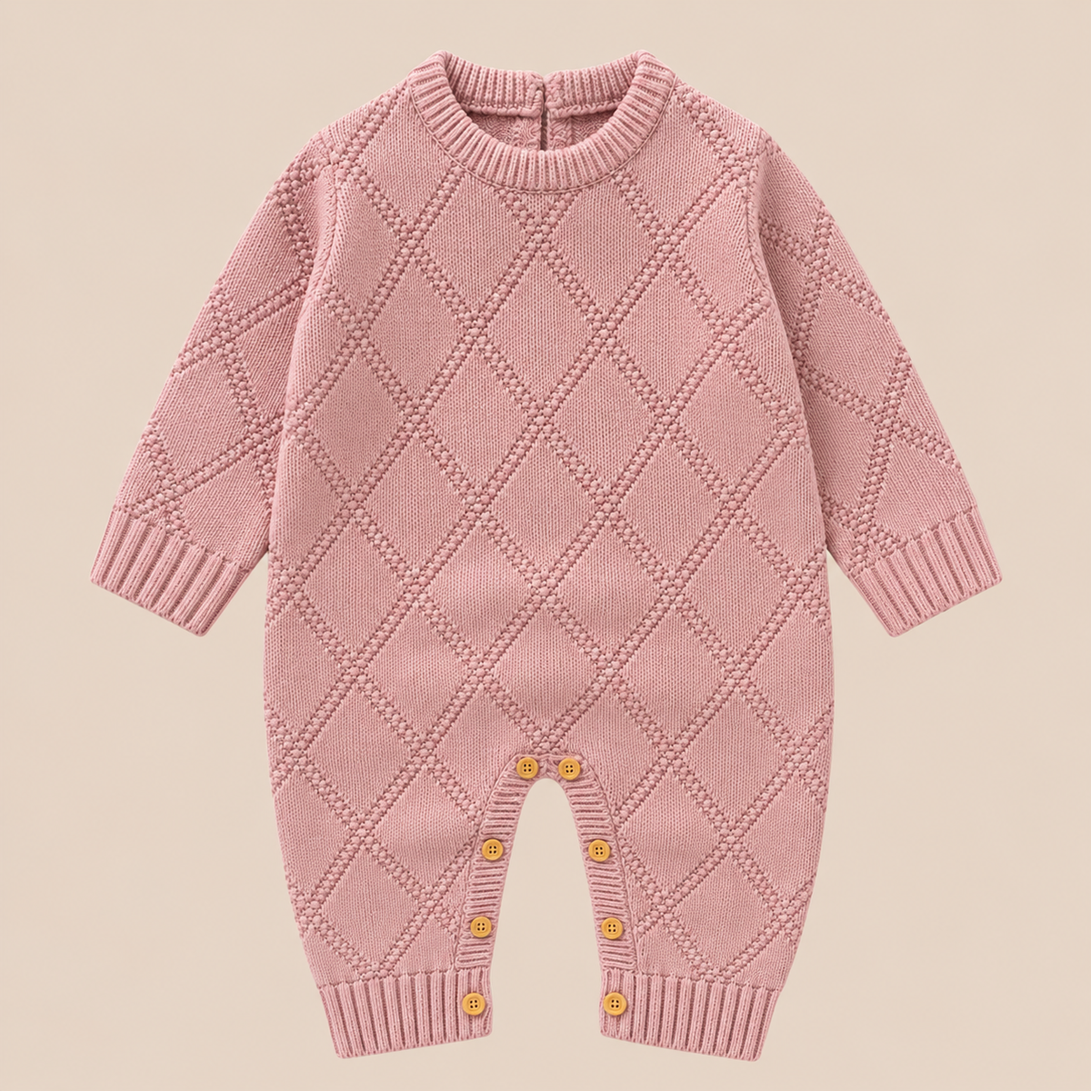 Dusty pink diamond-knit baby romper with long sleeves, ribbed neckline and wooden-look inseam buttons.