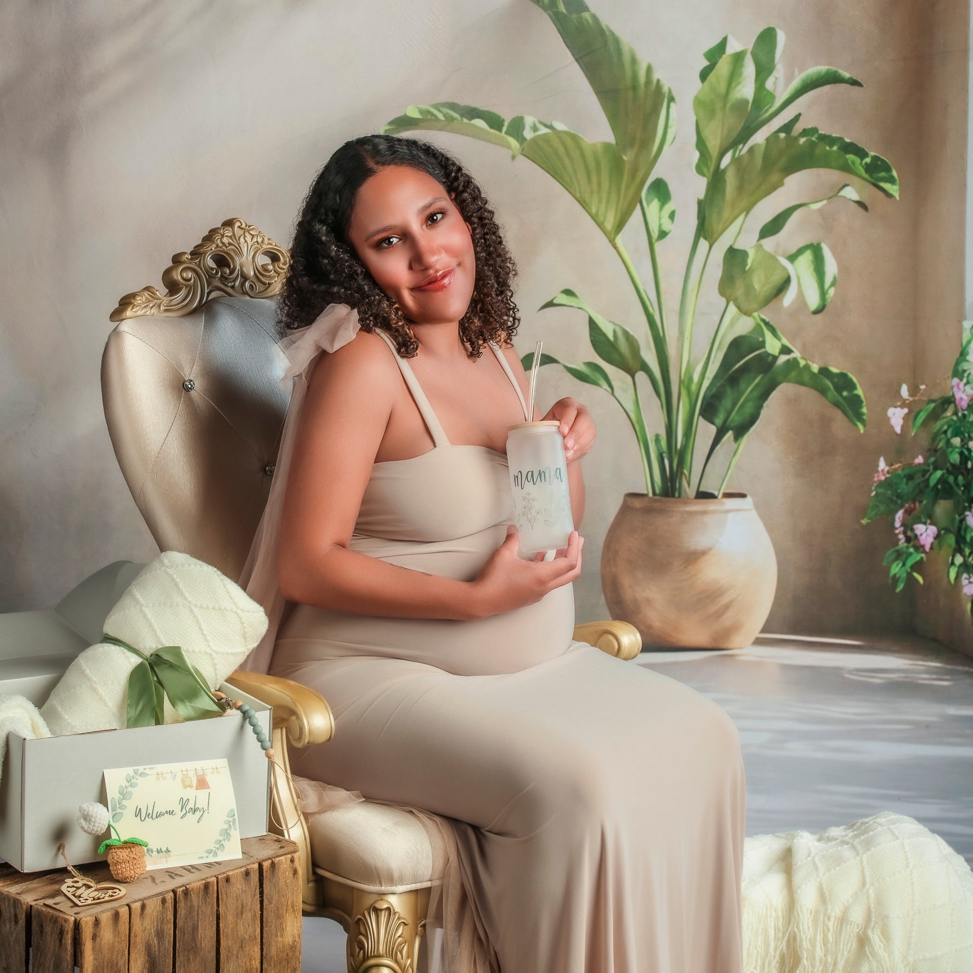 Woman in a beige dress holding a product in a decorated room with plants and gift boxes.