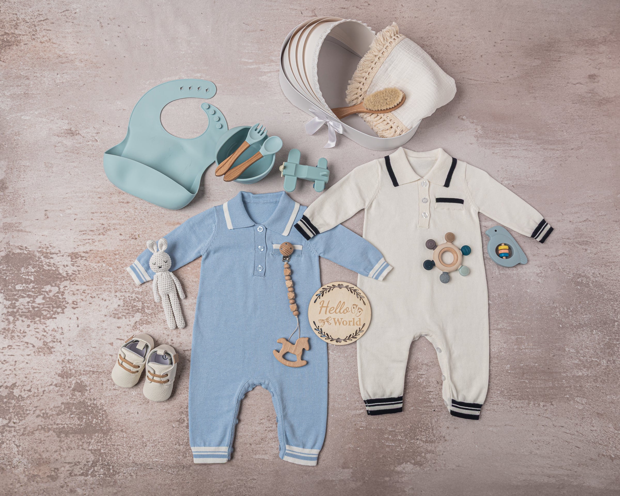 Luxury baby boy gift set in a classic blue and white theme, including premium cotton outfits, a soft swaddle, leather shoes, sustainable teethers, and a bunny plush