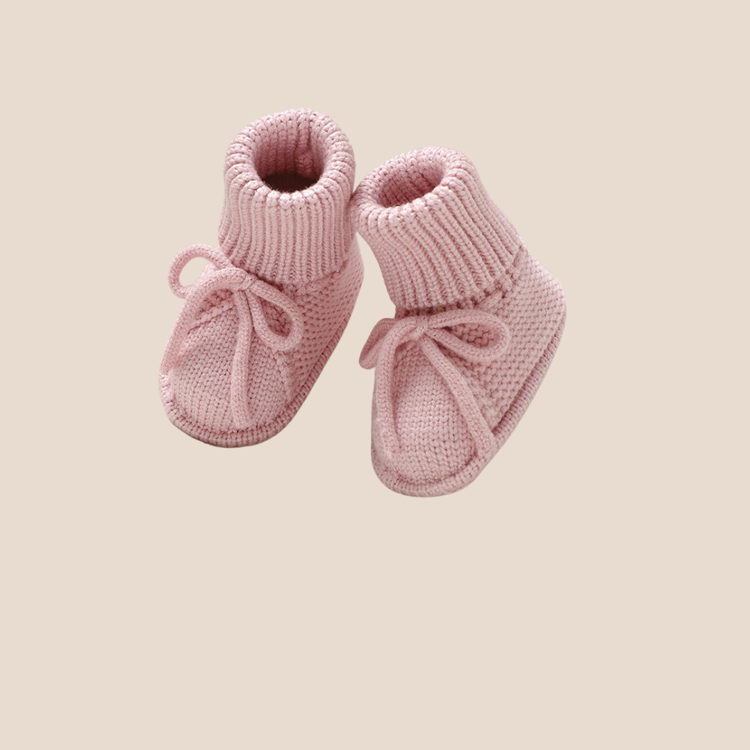 Blush pink hand-knitted baby booties for baby girls – a beautiful choice for personalized baby shower gifts, newborn keepsake bundles, and custom gifting for clients.