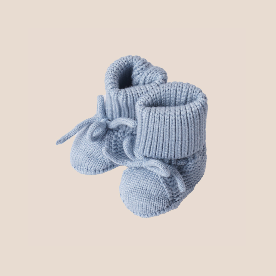 Mist blue hand-knitted baby booties made from soft cotton yarn – ideal for newborn baby shower gifts, personalized custom baby boxes, and premium client gifting.