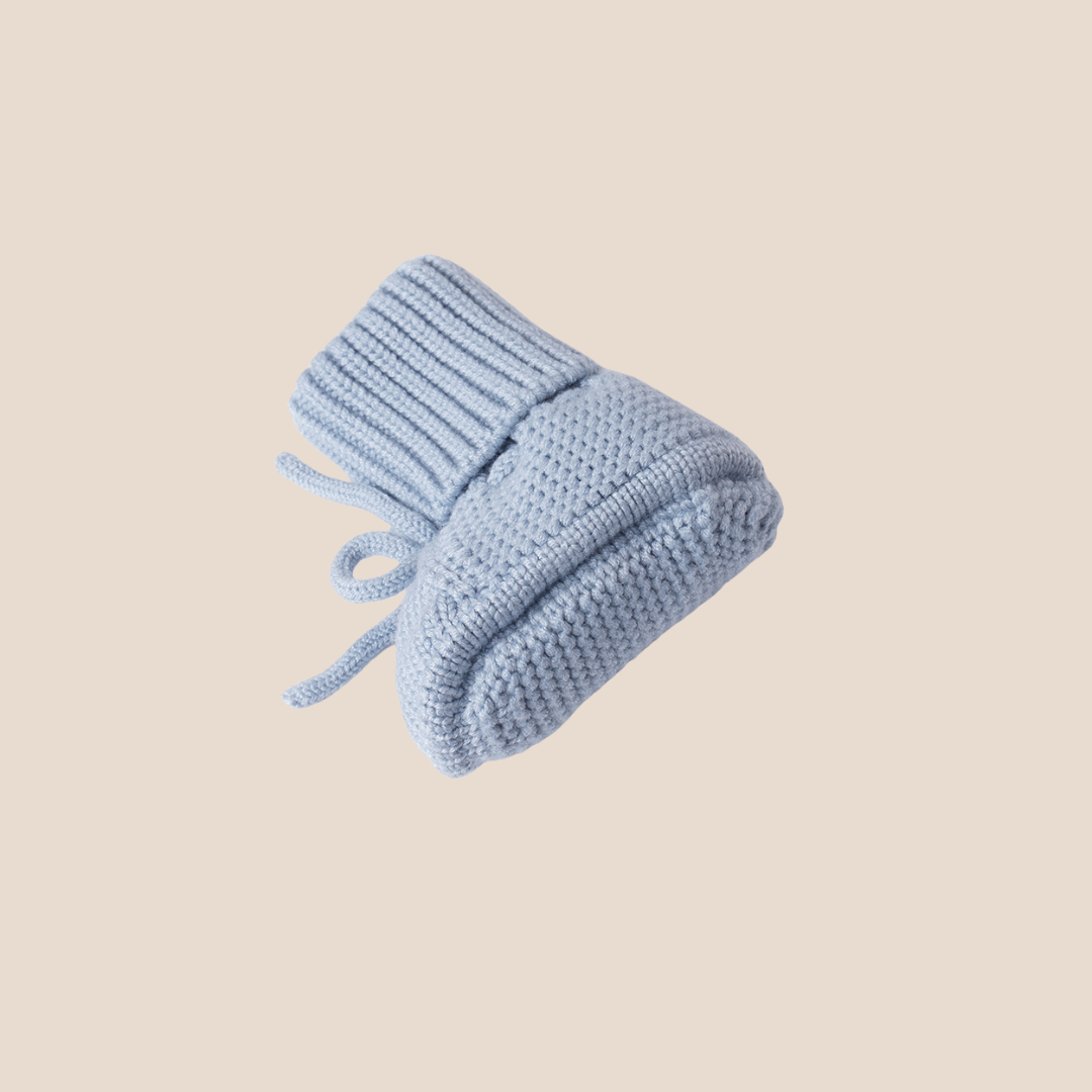 Sky blue knitted baby booties with fold-over ribbed cuffs – soft and stylish choice for customized baby boy gifts, baby shower bundles, or exclusive client gift sets.