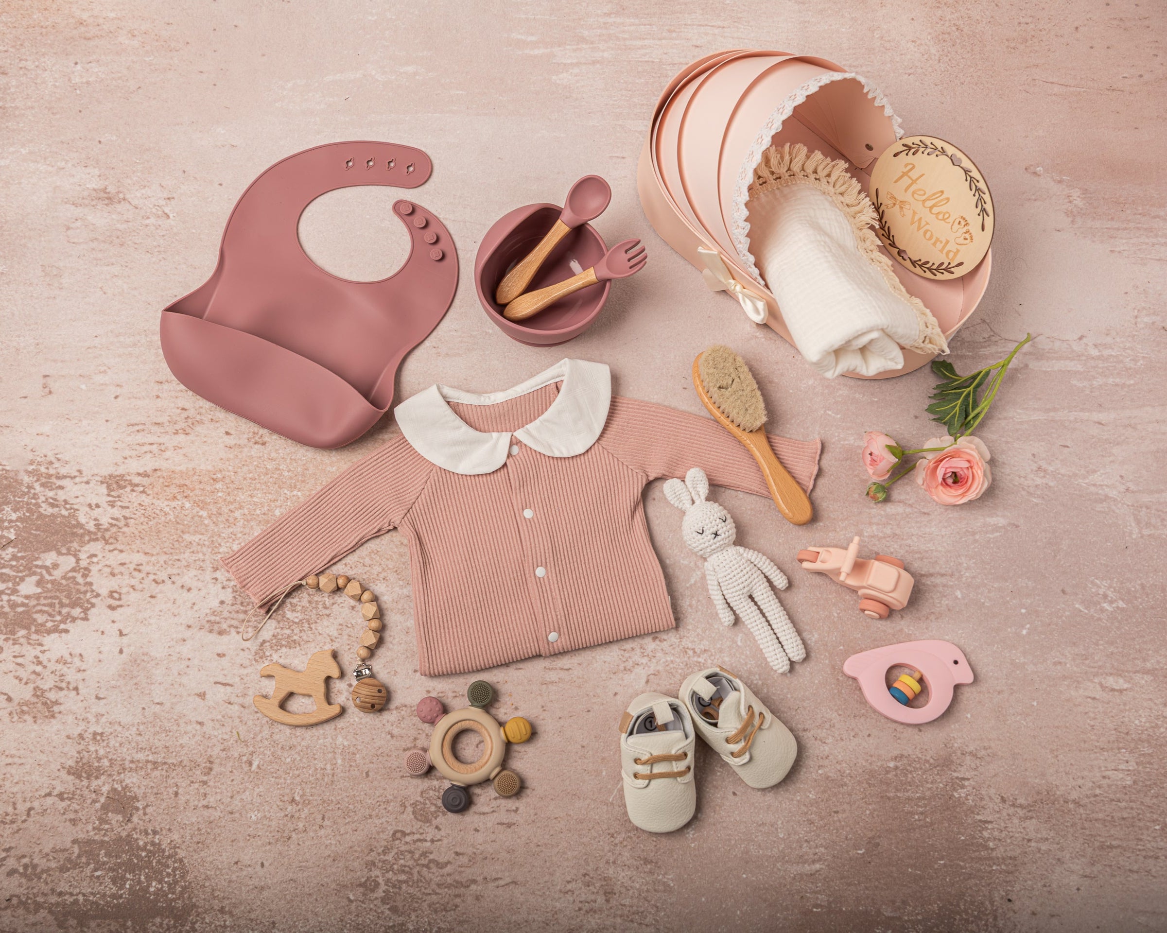 Exquisite baby girl gift set in soft pink and white, featuring 100% cotton outfits, a fringed swaddle, leather baby shoes, handmade bunny plush, and sustainable wooden and silicone toys, elegantly arranged for a luxury gifting experience.