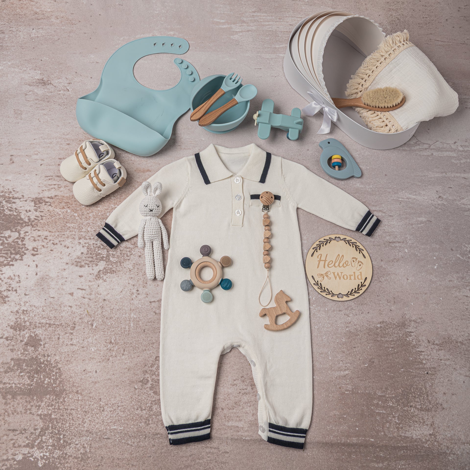 Luxurious baby boy gift basket, presented in a crib-shaped keepsake box, wrapped with netting and satin ribbon, containing elegant newborn essentials, eco-friendly toys, and premium mealtime accessories—a perfect corporate baby gift