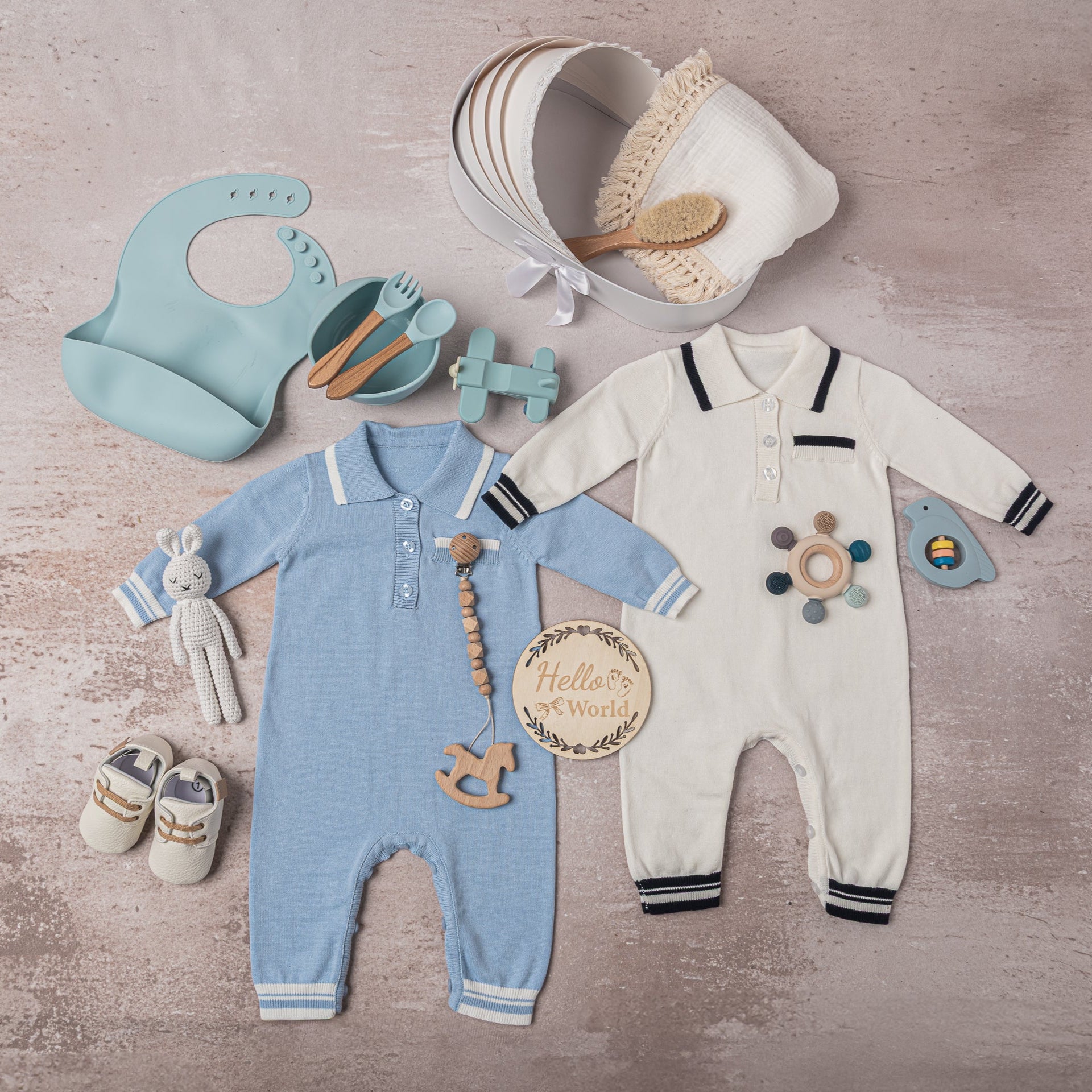 Thoughtfully curated baby boy accessories, including a wooden pacifier clip, bamboo hairbrush, airplane silicone teether, and handcrafted leather shoes—a sophisticated newborn gift set.