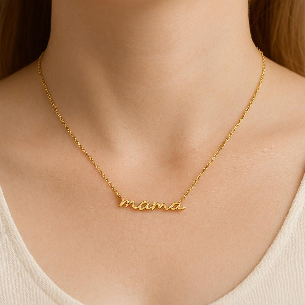 Gold 'mama' necklace on a person wearing a white top