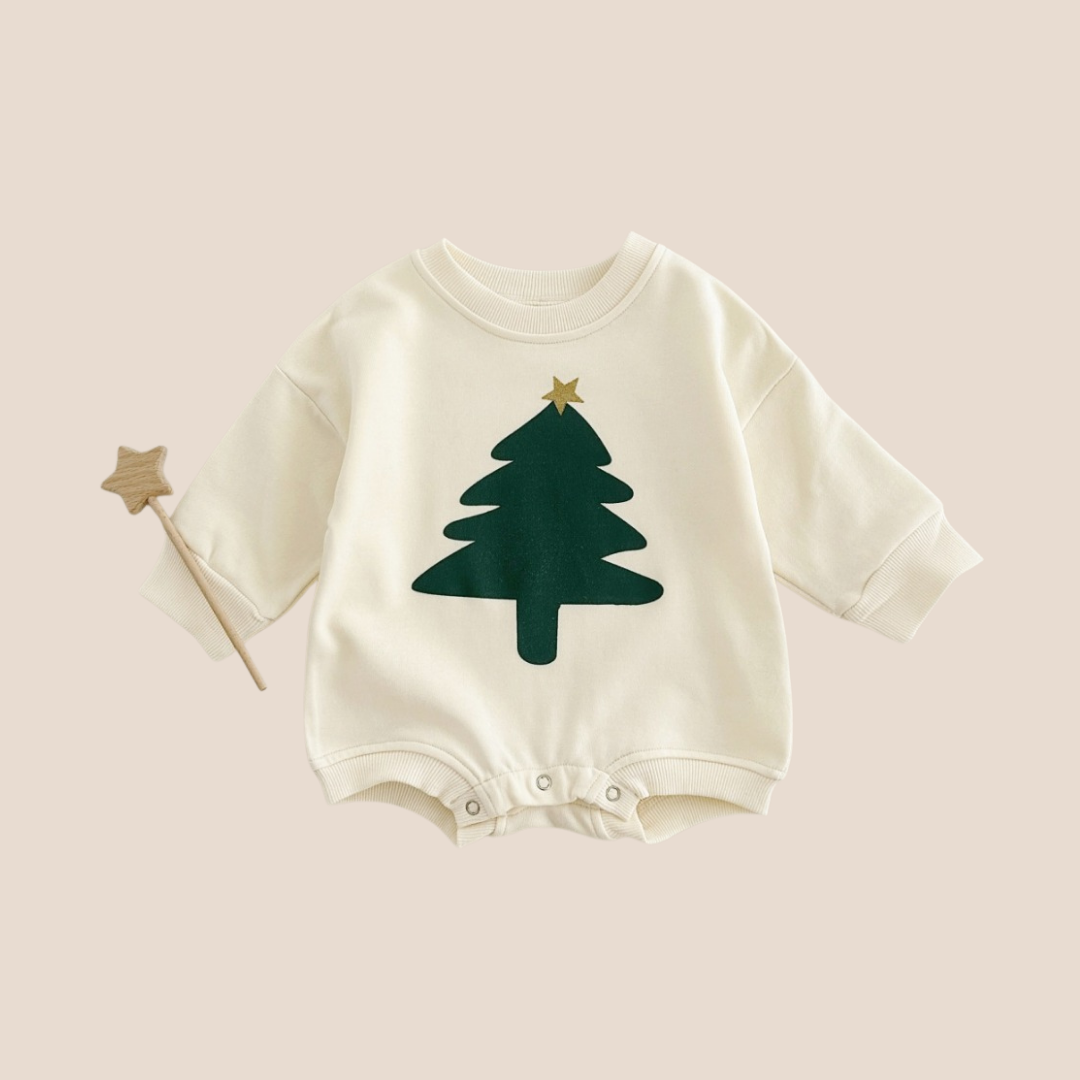 Baby onesie with green tree design on a beige background