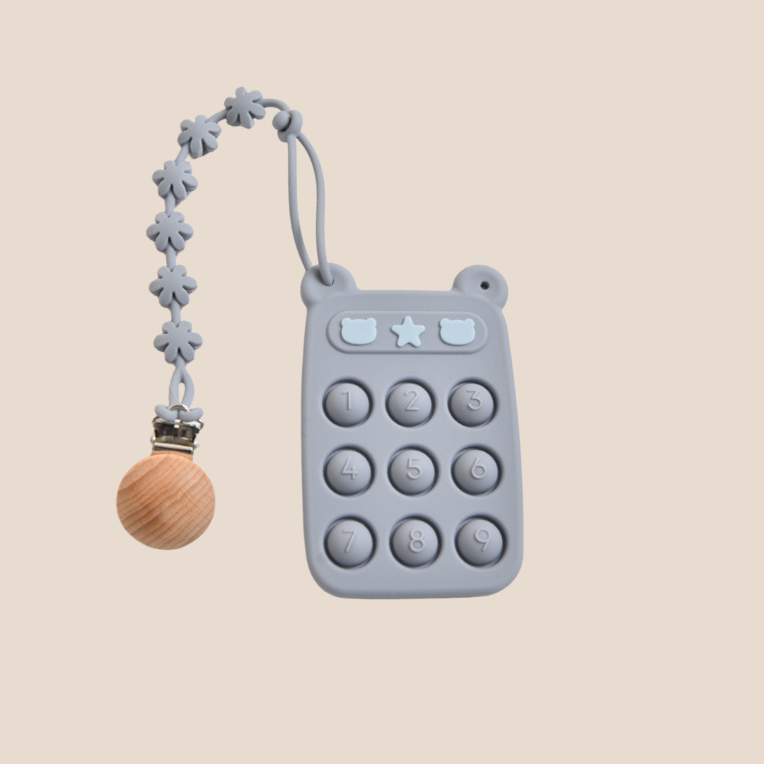 Gray teething toy with wooden ball and floral chain on a beige background