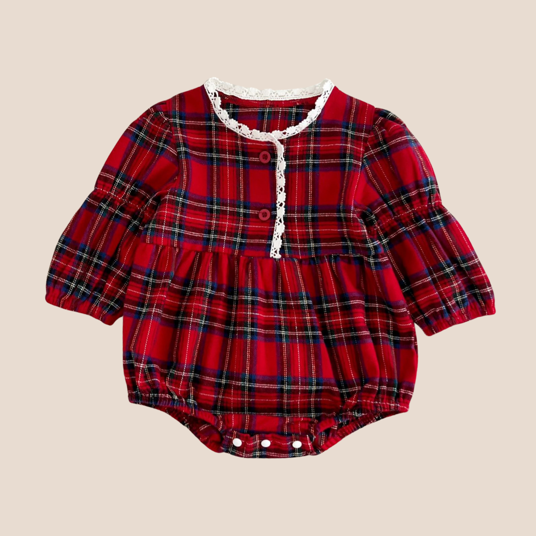 Red plaid baby romper with lace trim on a beige background