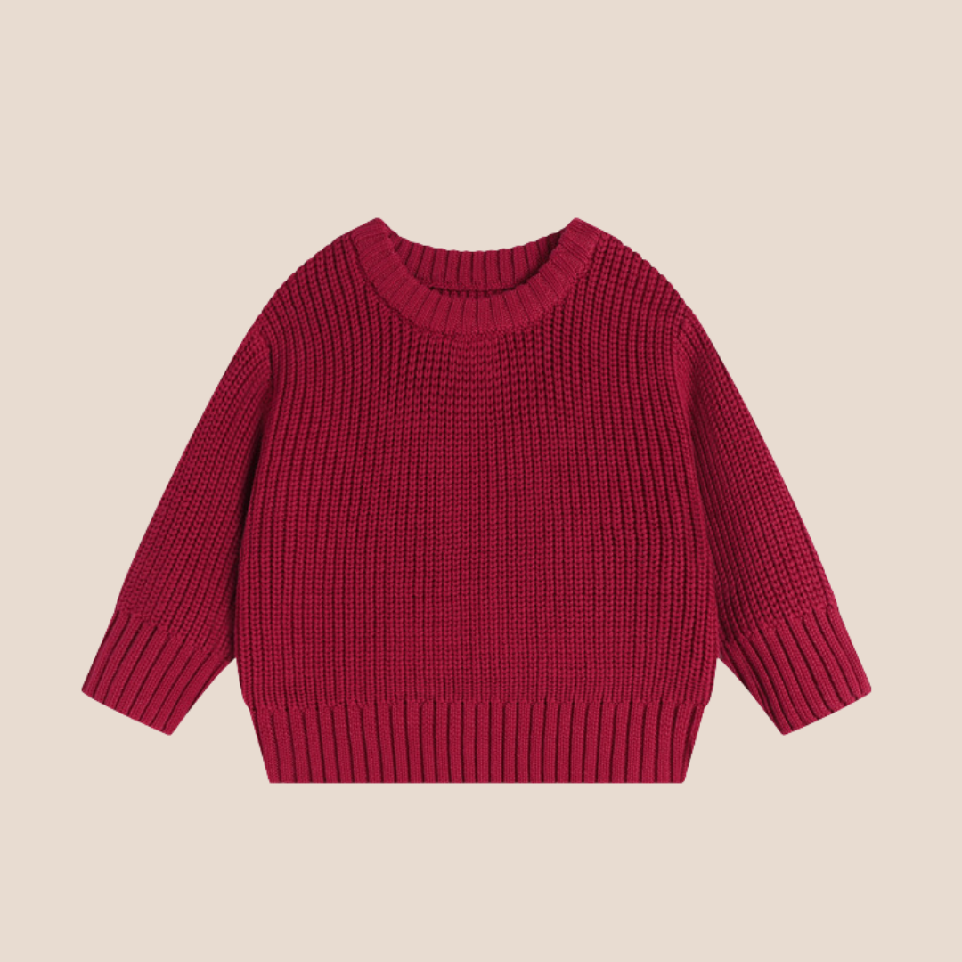 Red baby cotton knit sweater on a beige background