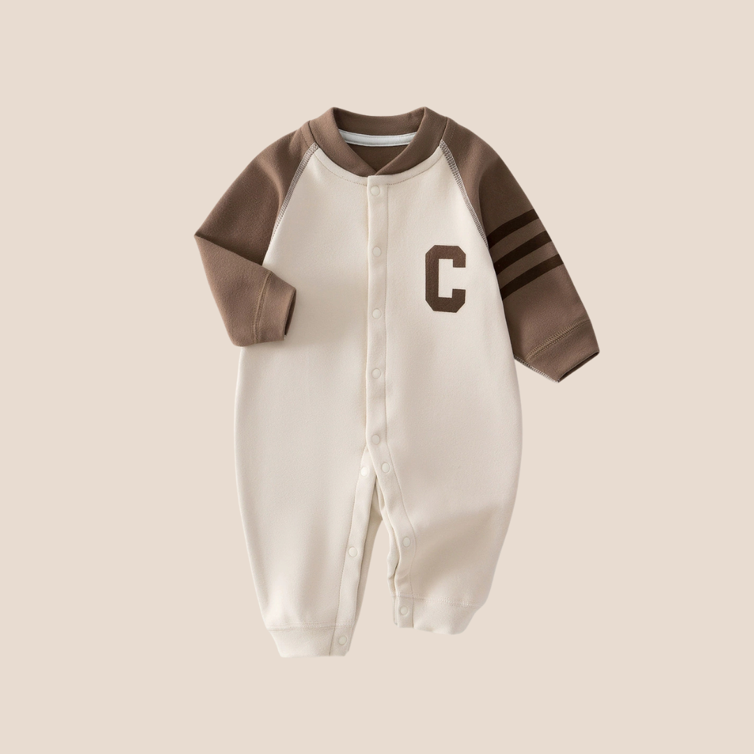 Cotton Craft Varsity C colorblock baby romper in mocha brown and cream with striped sleeves and snap closure.