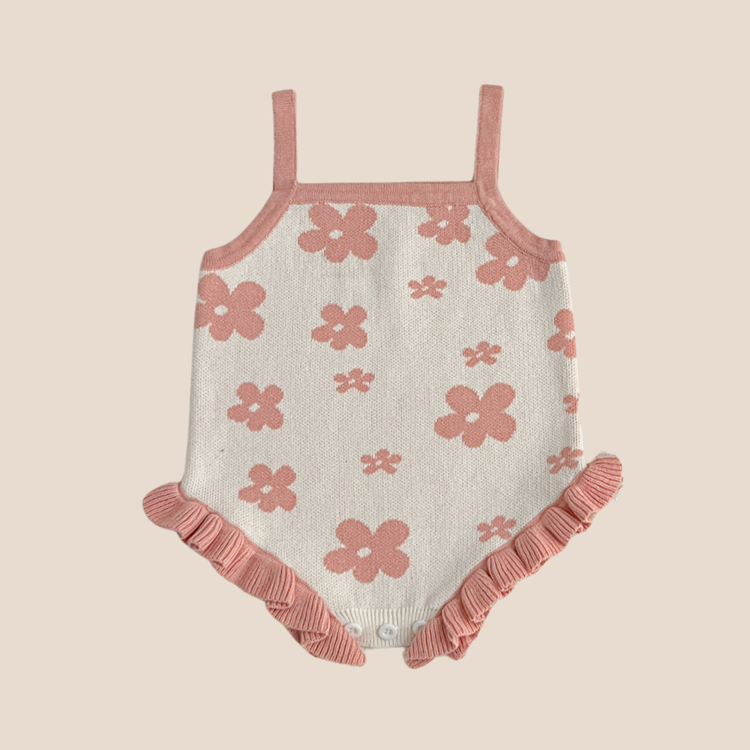 Floral knit baby romper with dusty pink flowers and ruffle trim for babies 3–6 months