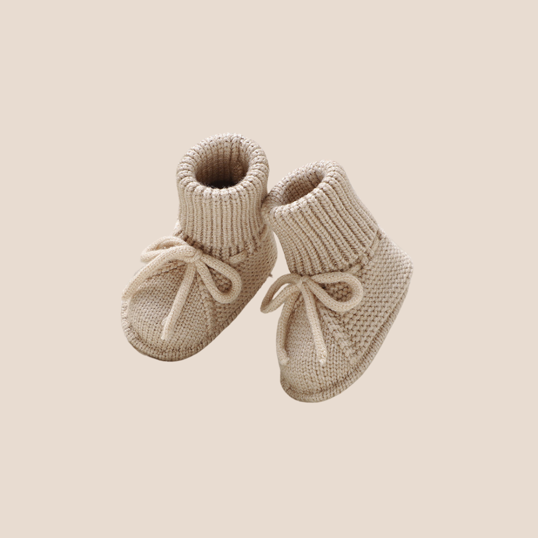 Sand beige cotton knit baby booties with tie-up design – perfect for gender-neutral baby shower gifts, custom baby gift boxes, and thoughtful client welcome hampers.