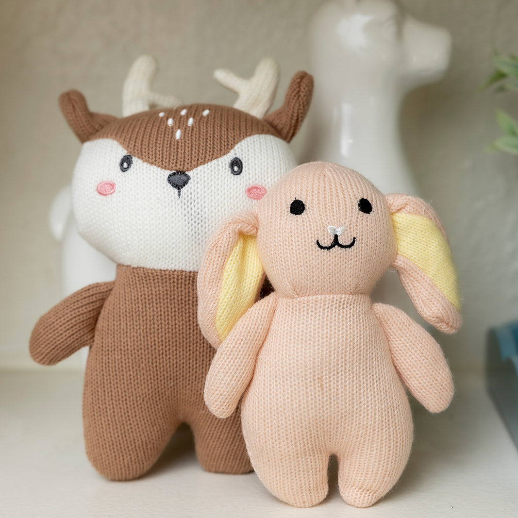 Two plush toys, one resembling a deer and the other a rabbit, on a neutral background.