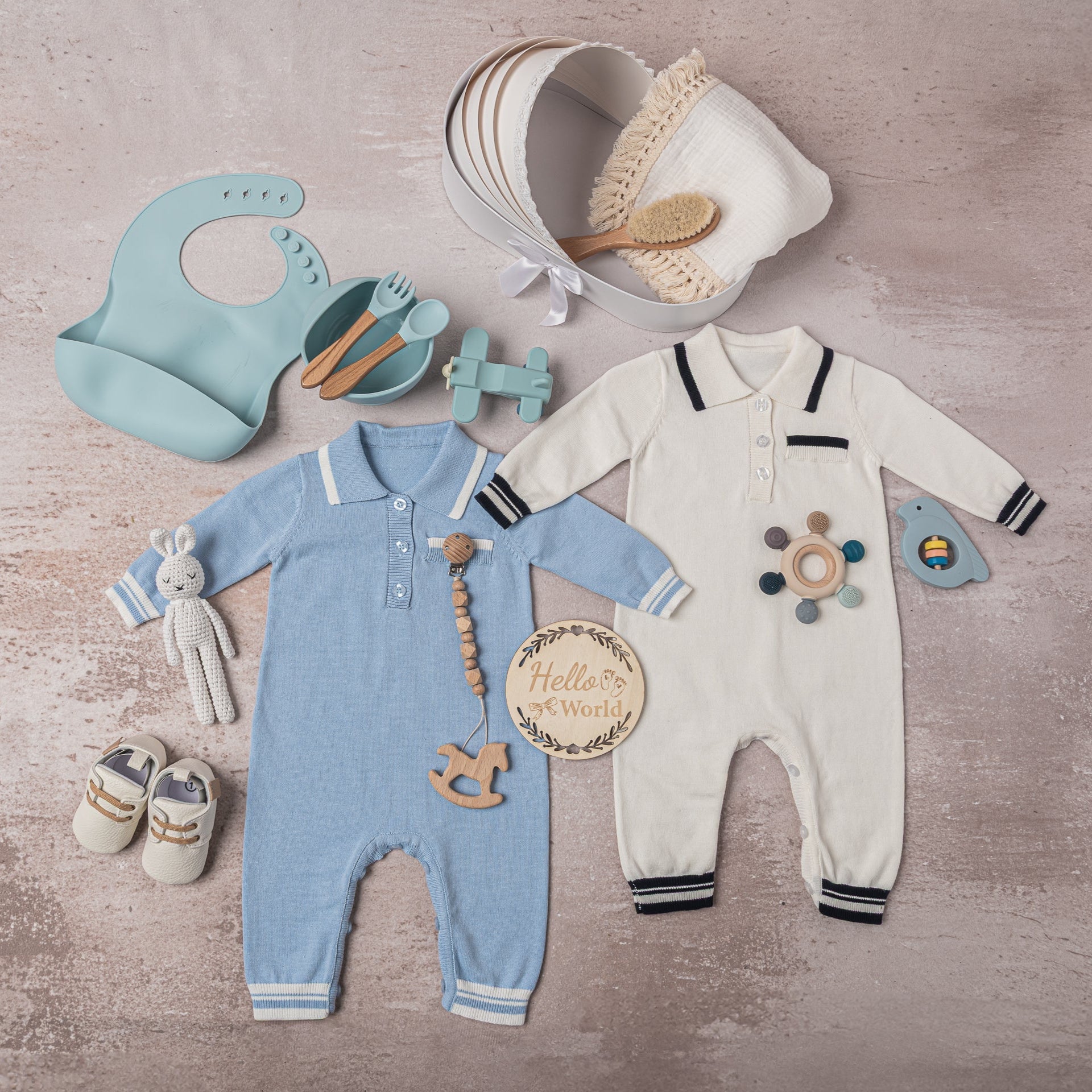 Luxury baby boy gift set in a classic blue and white theme, including premium cotton outfits, a soft swaddle, leather shoes, sustainable teethers, and a bunny plush