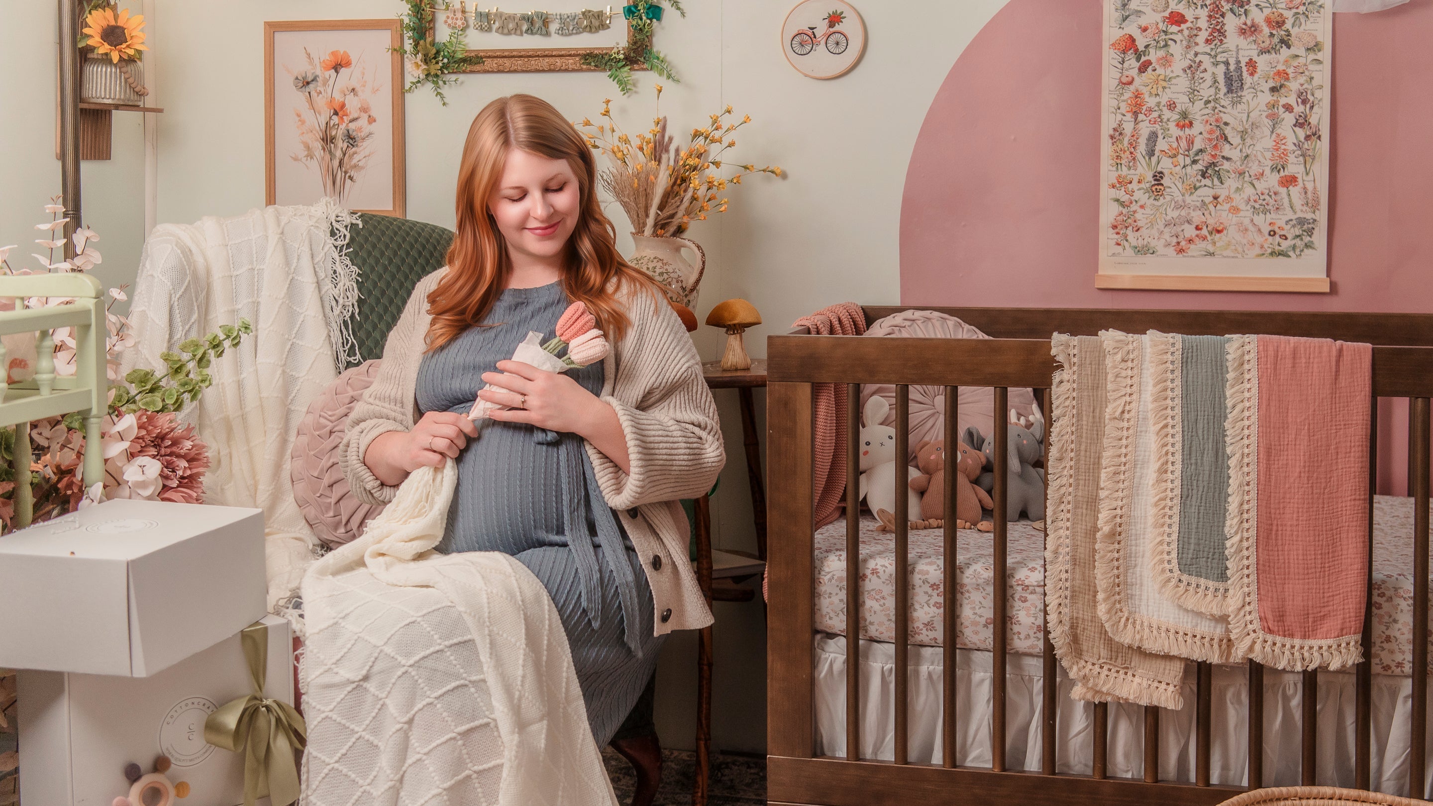 Woman holding a baby in a nursery with a crib and decorative elements.